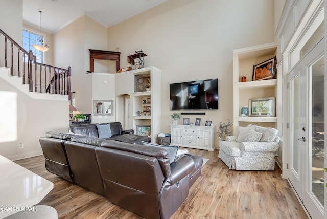 233 Moonlight Bay Dr, Panama City Beach, FL 32407 - living room with a towering ceiling, built in features, crown molding, stairs, and wood finished floors