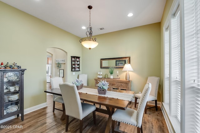 dining room with arched walkways, recessed lighting, wood finished floors, visible vents, and baseboards