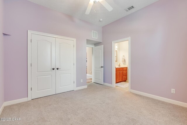 unfurnished bedroom featuring a closet, visible vents, light carpet, and baseboards