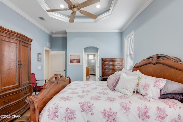 bedroom with visible vents, arched walkways, a raised ceiling, and crown molding