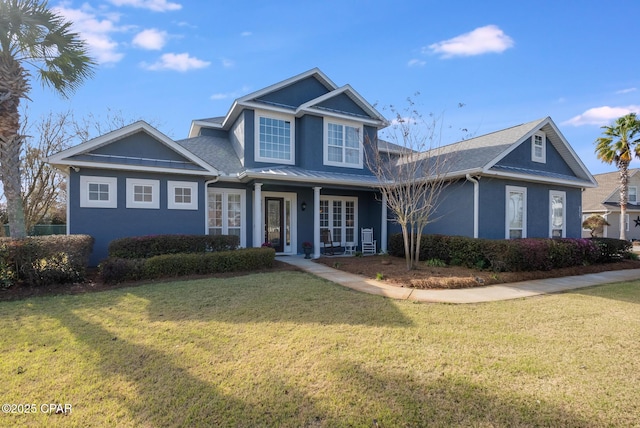 233 Moonlight Bay Dr, Panama City Beach, FL 32407 - view of front of property featuring a standing seam roof, a front yard, stucco siding, and french doors