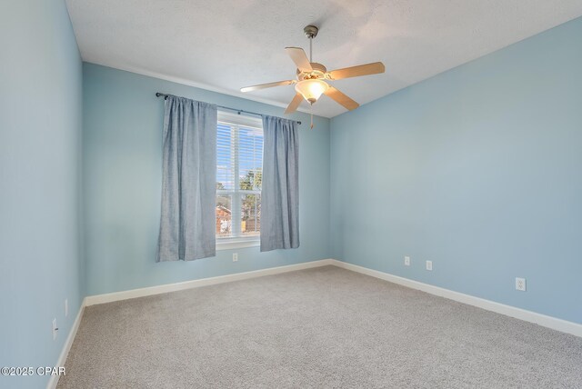 unfurnished room with carpet, ceiling fan, baseboards, and a textured ceiling