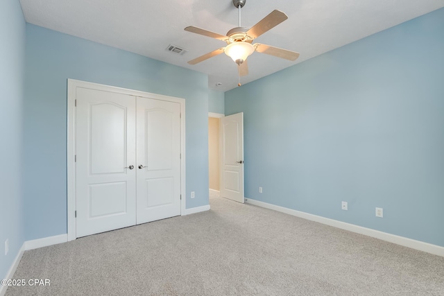 unfurnished bedroom featuring a closet, carpet flooring, visible vents, and baseboards