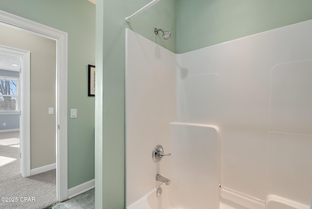 bathroom with shower / washtub combination and baseboards