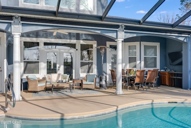 outdoor pool with a lanai, a patio area, outdoor lounge area, and a sink