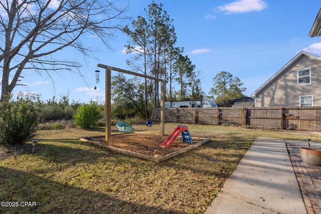 view of playground with a yard and fence