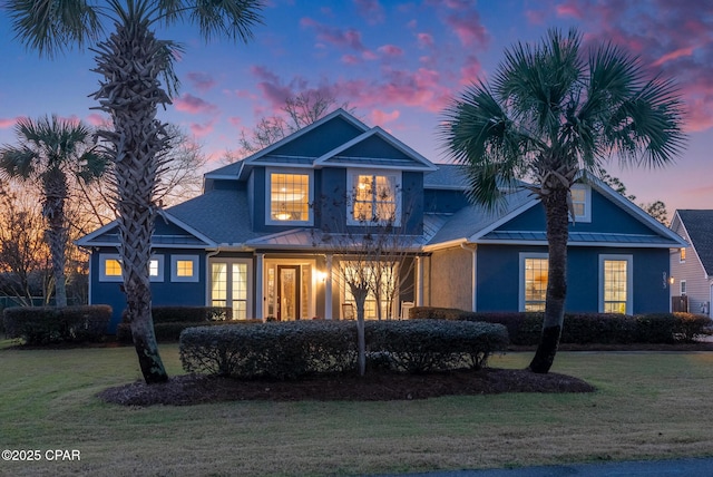 view of front of house with a standing seam roof, metal roof, and a lawn