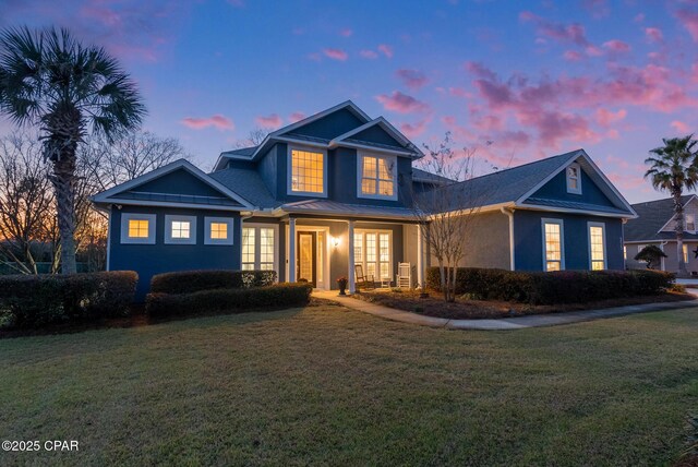 traditional home with metal roof, a front lawn, and a standing seam roof