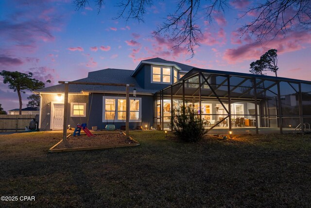 back of property with a lawn and a lanai