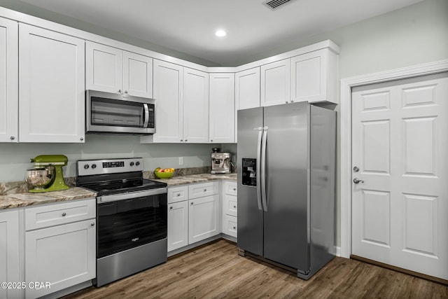 kitchen with dark wood-style floors, white cabinetry, and appliances with stainless steel finishes