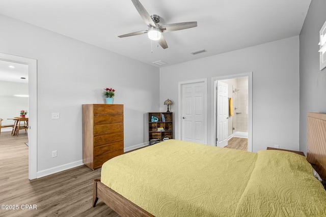 bedroom featuring visible vents, baseboards, ceiling fan, wood finished floors, and ensuite bathroom