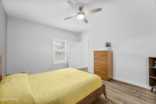 bedroom with wood finished floors, a ceiling fan, and baseboards