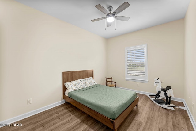 bedroom featuring a ceiling fan, baseboards, and wood finished floors