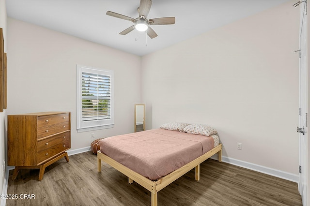 bedroom with ceiling fan, wood finished floors, and baseboards