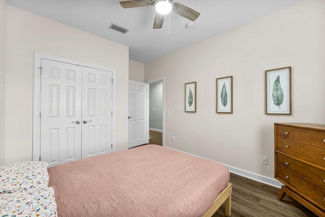 bedroom featuring baseboards, visible vents, a ceiling fan, dark wood-style flooring, and a closet