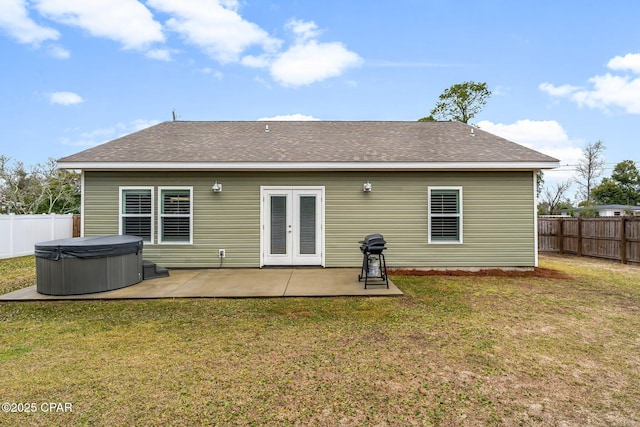 back of house with a patio, a fenced backyard, a yard, french doors, and a hot tub