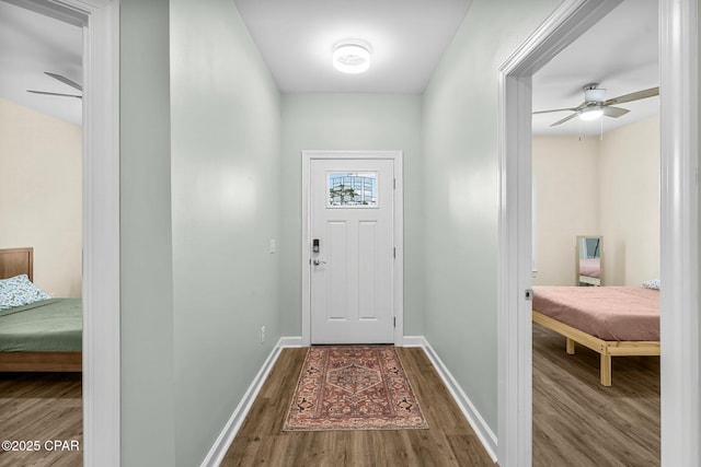 doorway to outside featuring ceiling fan, baseboards, and wood finished floors