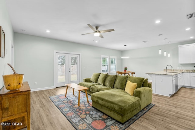 living area featuring recessed lighting, a ceiling fan, baseboards, visible vents, and light wood-style floors