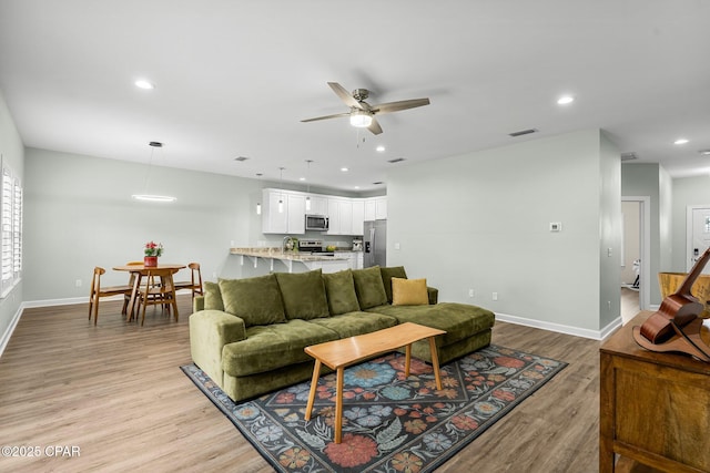 living room featuring light wood finished floors and recessed lighting