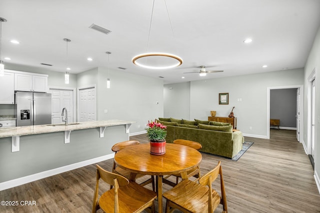 dining space featuring light wood-type flooring, visible vents, baseboards, and recessed lighting