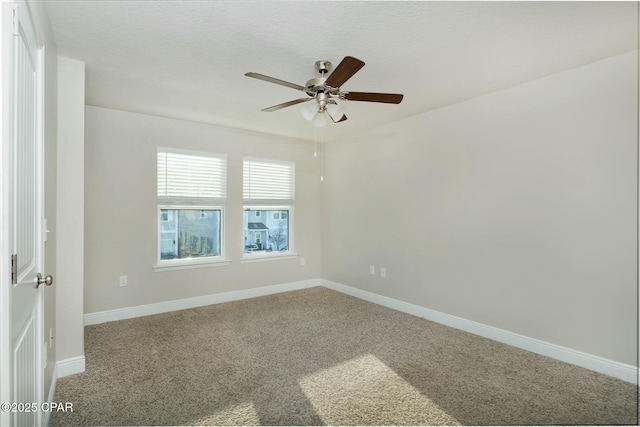 carpeted spare room with ceiling fan, baseboards, and a textured ceiling