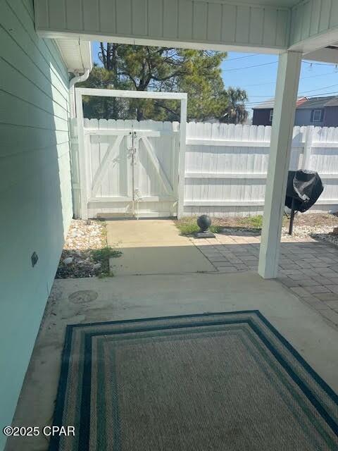 view of patio featuring fence and a gate