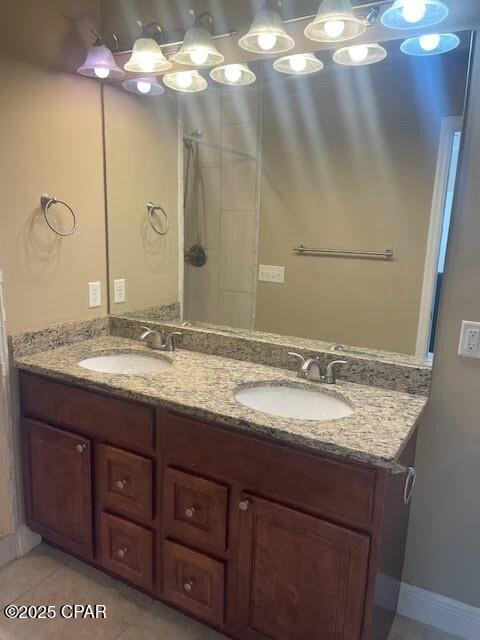 bathroom with double vanity, tile patterned flooring, and a sink