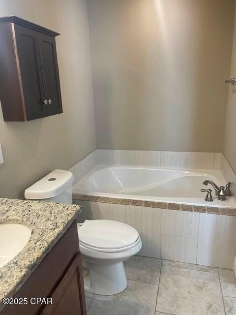 bathroom featuring a garden tub, vanity, toilet, and tile patterned floors