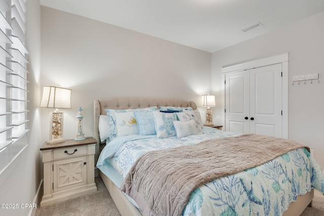 bedroom featuring light carpet, baseboards, visible vents, and a closet