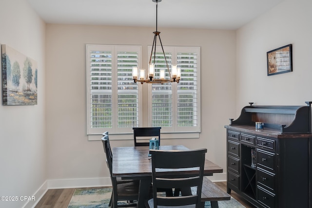 dining area featuring baseboards, a notable chandelier, and wood finished floors