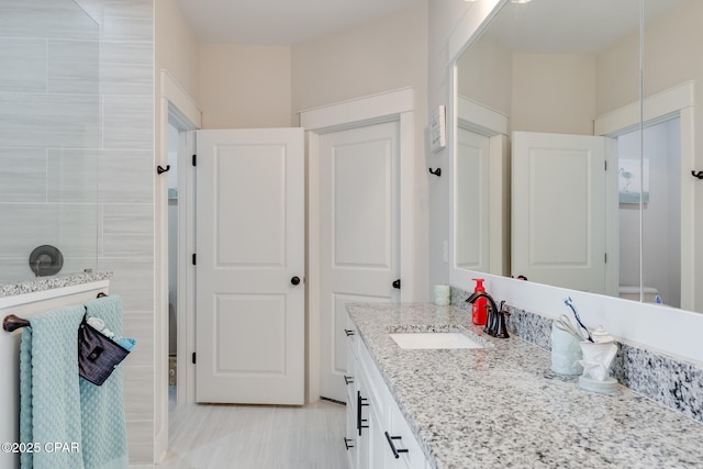 bathroom featuring a tile shower and vanity