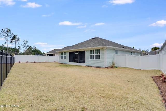 back of property with a fenced backyard and a lawn