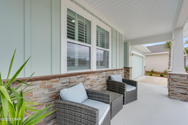 view of patio / terrace with a garage, covered porch, and driveway