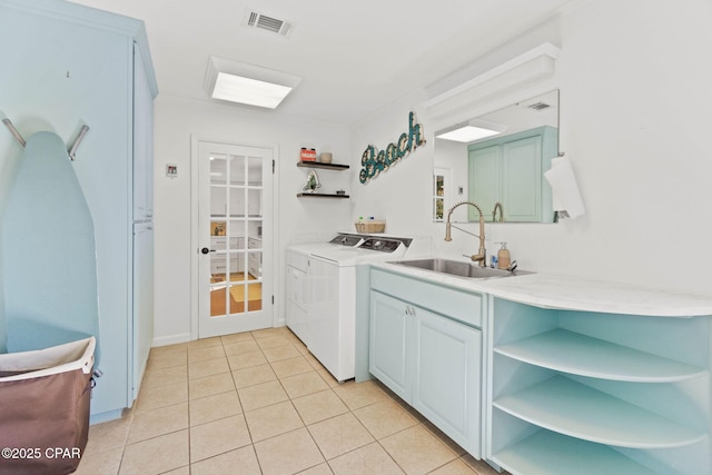 kitchen featuring open shelves, light countertops, visible vents, washing machine and dryer, and a sink