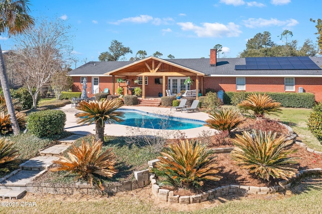 outdoor pool with a patio and french doors