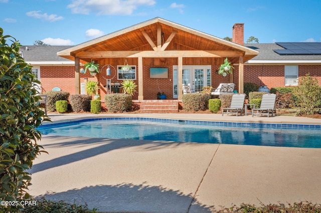 outdoor pool with a patio and french doors