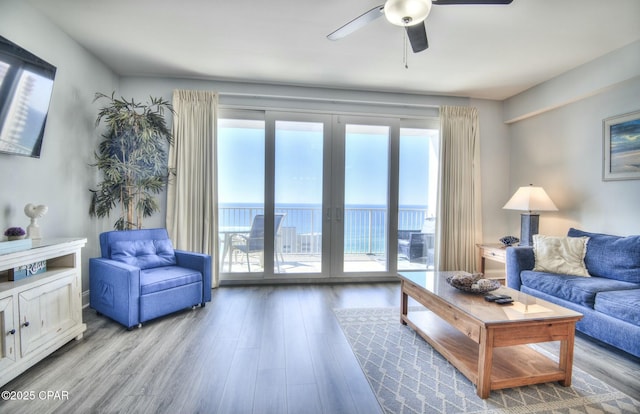 living area featuring french doors, ceiling fan, and wood finished floors