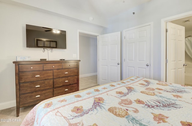 bedroom featuring baseboards, lofted ceiling, and visible vents