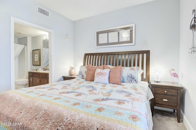 carpeted bedroom featuring connected bathroom, baseboards, and visible vents