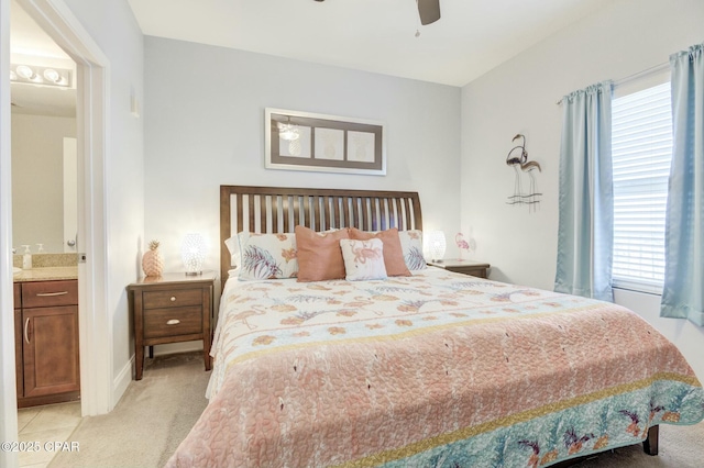bedroom featuring multiple windows, light carpet, a ceiling fan, and connected bathroom