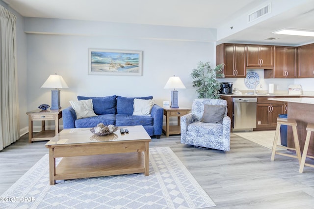 living room featuring light wood-style flooring and visible vents