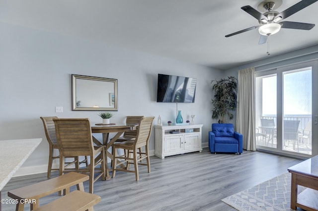 dining space with baseboards, ceiling fan, and wood finished floors