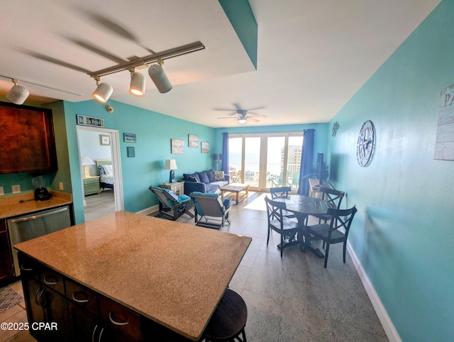 kitchen with a center island, open floor plan, ceiling fan, and baseboards