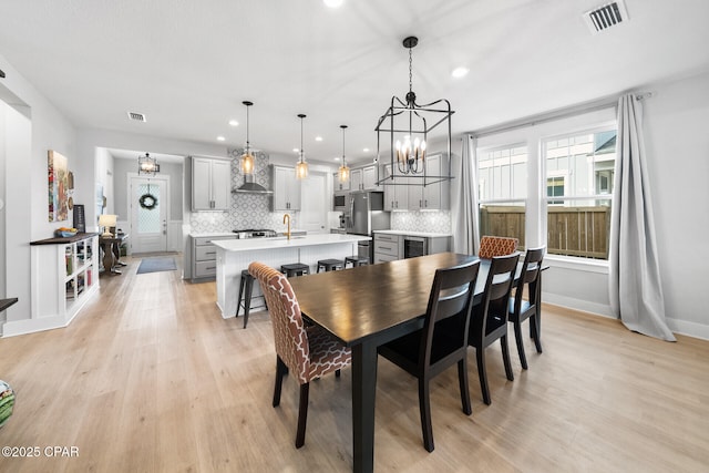 dining area featuring light wood-style floors, baseboards, visible vents, and recessed lighting