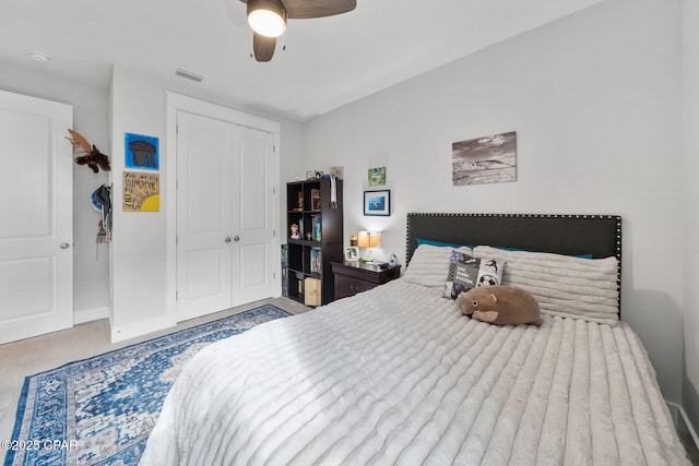 carpeted bedroom with ceiling fan, visible vents, and a closet