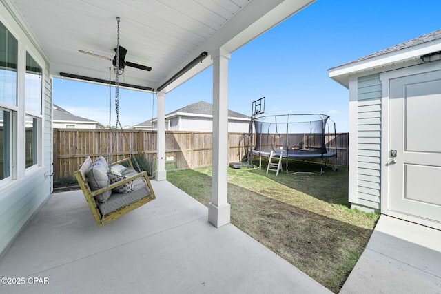 view of patio / terrace featuring a fenced backyard, a trampoline, and a ceiling fan