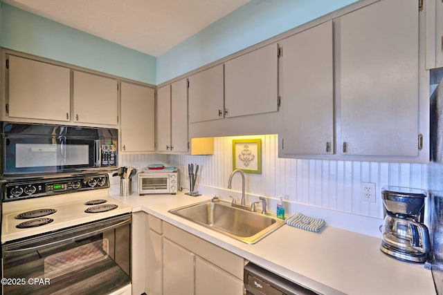 kitchen with black microwave, a toaster, range with electric cooktop, a sink, and light countertops