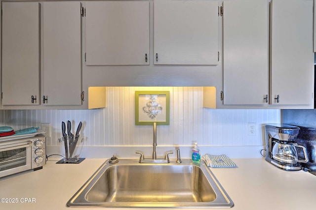 kitchen featuring light countertops, a sink, and a toaster