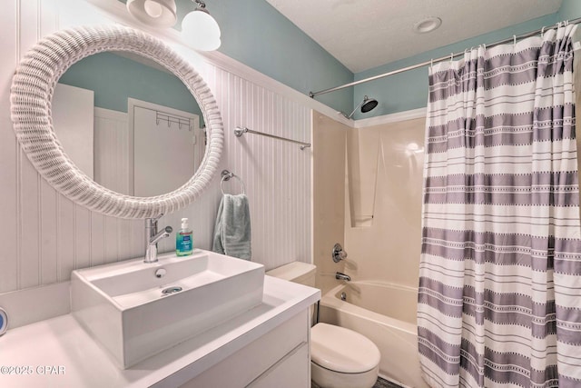 bathroom featuring a textured ceiling, vanity, toilet, and shower / bathtub combination with curtain