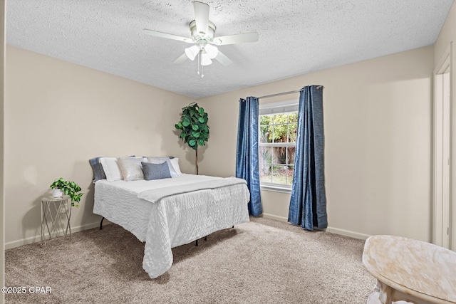 bedroom featuring light carpet, a textured ceiling, a ceiling fan, and baseboards